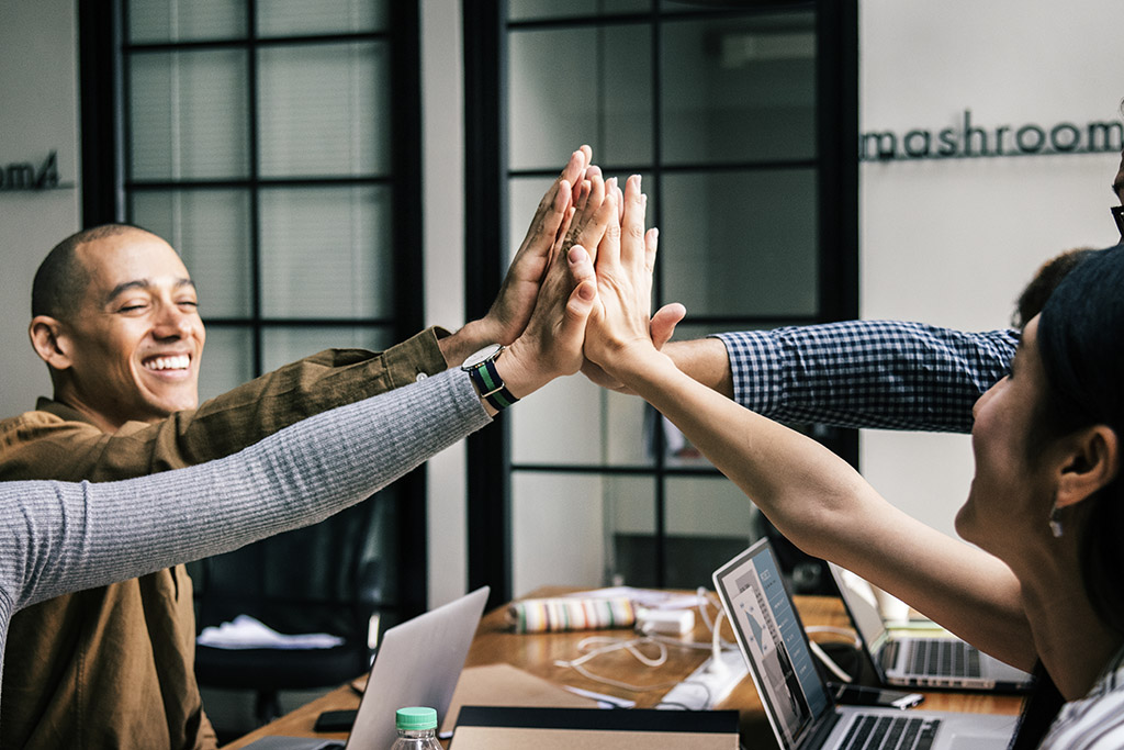 Groep mensen geeft elkaar een high five